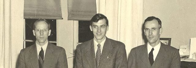 A vintage black-and-white photo of three men in suits, cropped wide, from a 1950s family portrait